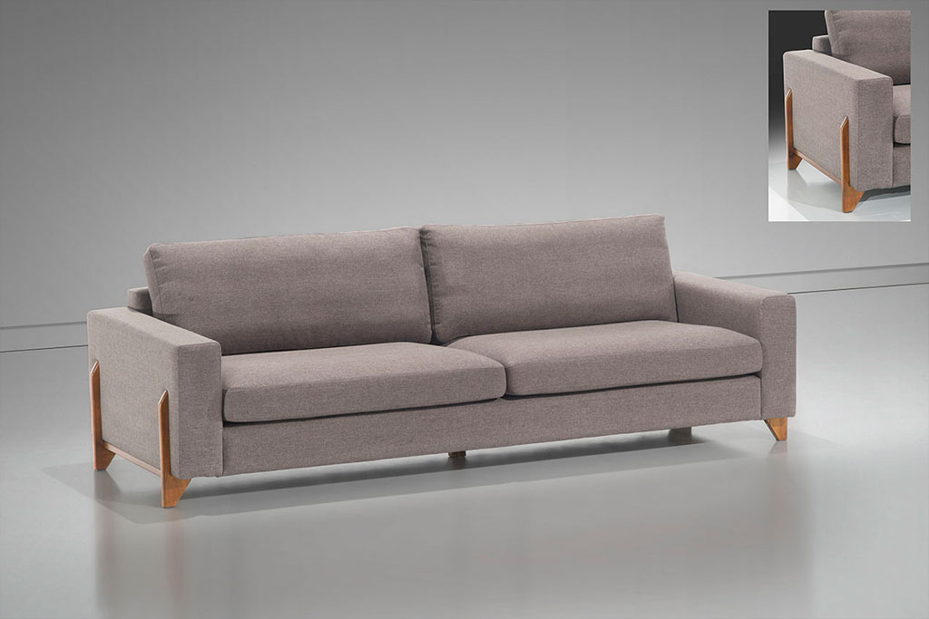 A imagem mostra um espaço com parede e piso brancos. Ao centro encontra-se o sofá Madrid, na cor cinza claro, seus pés são de madeira. No canto superior direito há uma pequena imagem mostrando o detalhe dos pés na lateral do sofá.