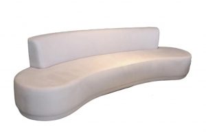 A imagem mostra um espaço com fundo totalmente branco. No centro encontra-se o sofá curve na cor branca, ele tem forma de arco e não possui braços.