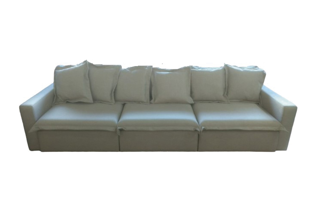 A imagem mostra um ambiente com fundo totalmente branco. No centro encontra-se o sofá Mikonos, na cor verde.